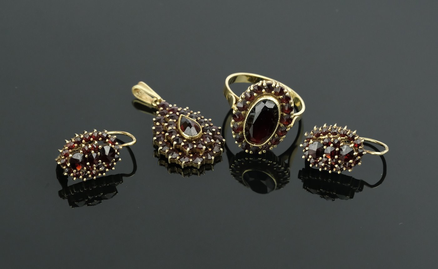 .. - Souprava náušnic, prstenu a závěsu s českými granáty, zlato 585/1000, značeno platnou puncovní značkou "čejka", hrubá hmotnost 15,17 g